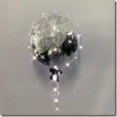One bubble transparent balloon with happy birthday print on balloon and black silver balloons inside
