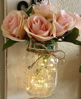 Led lights in a jar with 6 Pink roses and raffia